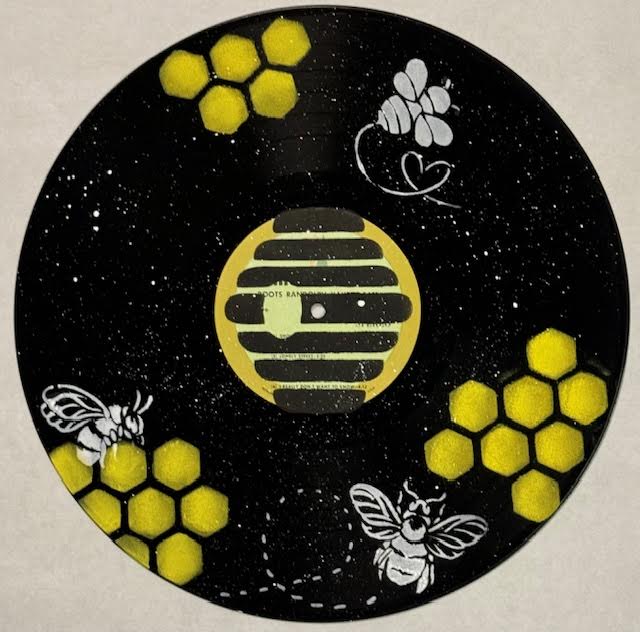 An old record that's got bee's and honeycomb painted on it. 