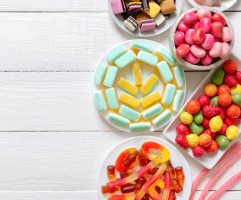 variety of gummy candies on a white wooden table