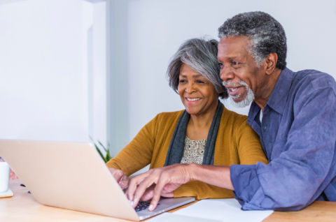 Senior couple looking at laptop screen