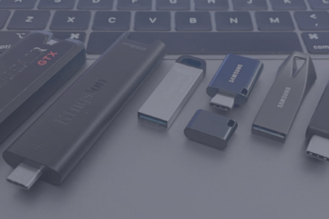 Assorted USB flash drives on top of laptop keyboard